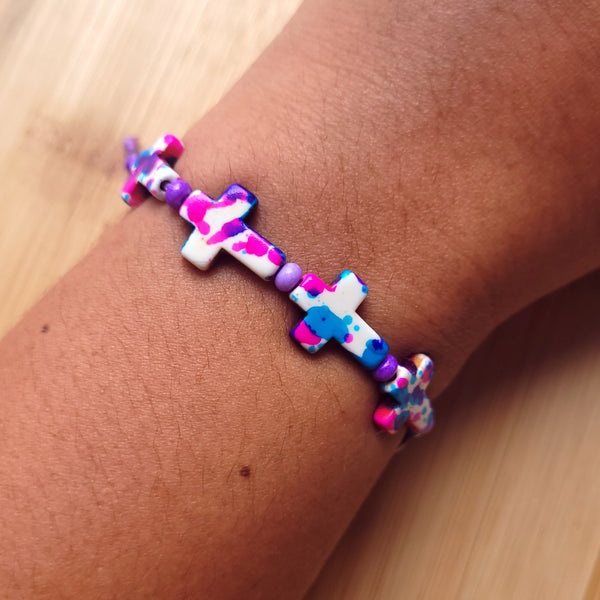 Pulsera de cruces con tonos azules, rosados, blancos y violetas.