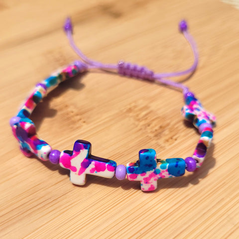 Pulsera de cruces con tonos azules, rosados, blancos y violetas.